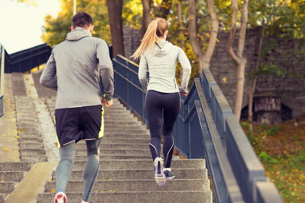Couple running upstairs in city park — Stock Photo, Image