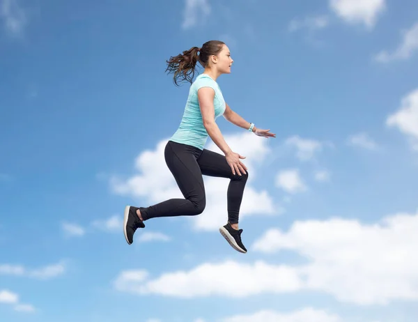 Szczęśliwy uśmiech sportowy młoda kobieta skacze w powietrzu — Zdjęcie stockowe