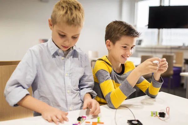 Glückliche Kinder bauen Roboter in der Robotikschule — Stockfoto