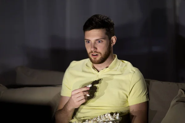 Uomo guardando la tv e mangiare popcorn di notte — Foto Stock