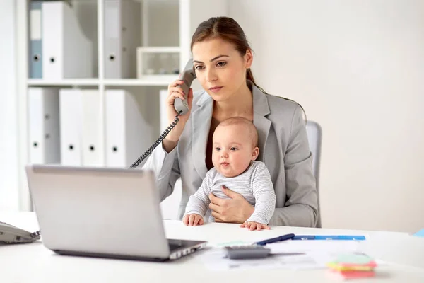 Mujer de negocios con bebé llamando por teléfono en la oficina — Foto de Stock