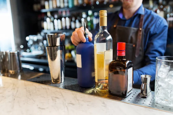 Barman con shaker, alcool e jigger al bar — Foto Stock