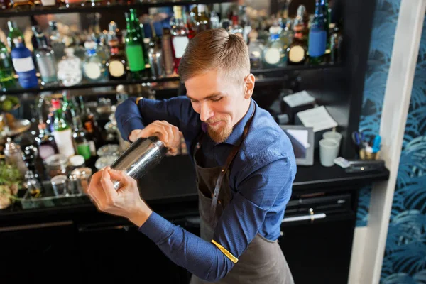 Szczęśliwy barman z shaker przygotowania koktajlu w barze — Zdjęcie stockowe