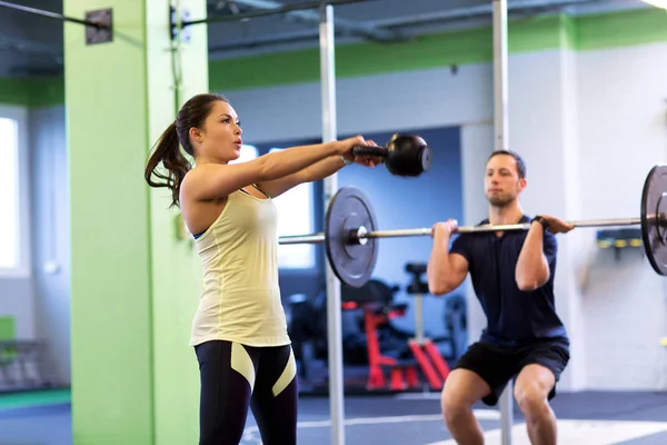 Mann und Frau mit Gewichten trainieren im Fitnessstudio — Stockfoto