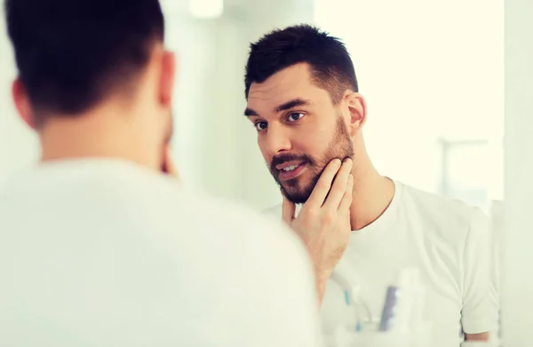 Felice giovane cercando di specchio a casa bagno — Foto Stock