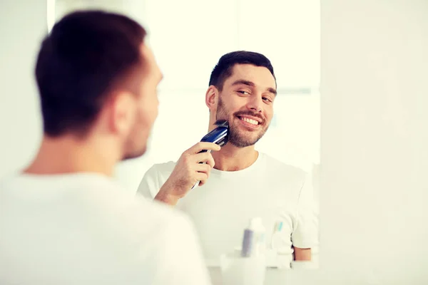 Hombre barba de afeitar con trimmer en el baño —  Fotos de Stock