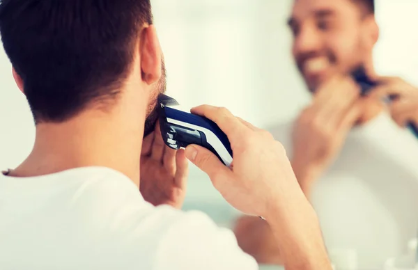 Primer plano del hombre afeitando la barba con trimmer —  Fotos de Stock