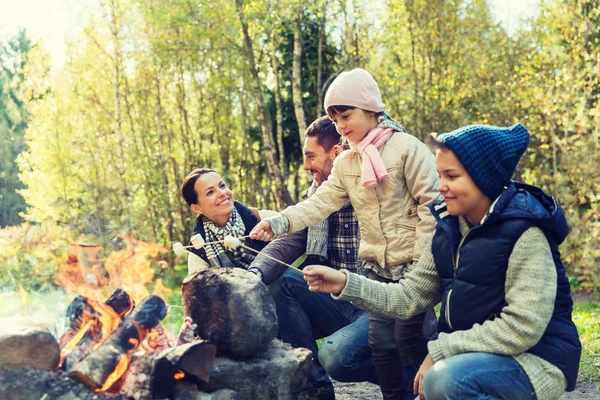 Familia feliz asado malvavisco sobre fogata — Foto de Stock