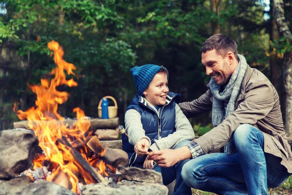 Père et fils rôtissant guimauve sur feu de camp — Photo