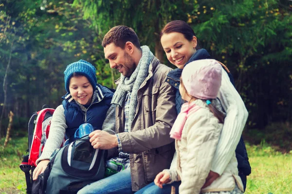 Glückliche Familie mit Rucksack und Thermoskanne im Camp — Stockfoto