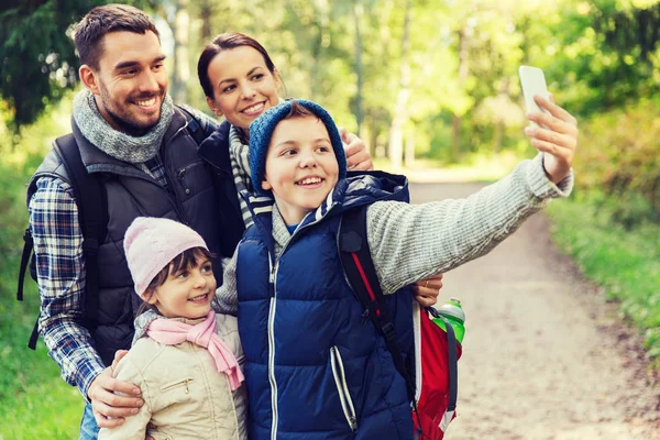 Rodziny z plecakami biorąc selfie przez smartfona — Zdjęcie stockowe