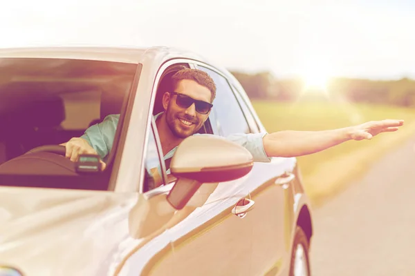 Pria bahagia dengan nuansa mengemudi mobil dan melambaikan tangan — Stok Foto