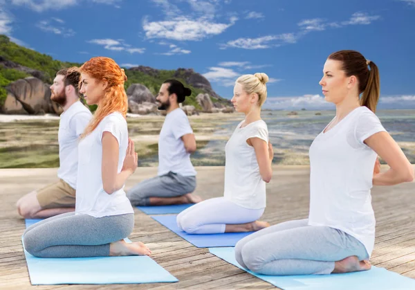 Mensen die yoga in held pose buitenshuis — Stockfoto