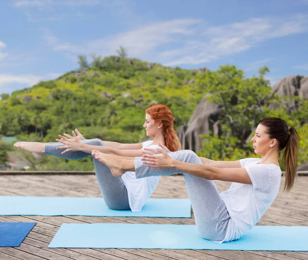 Mujeres haciendo yoga en media embarcación posan al aire libre — Foto de Stock