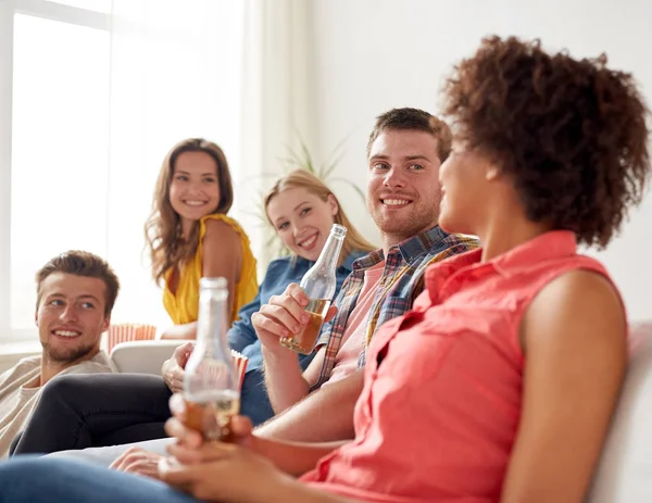 Amici felici con popcorn e birra a casa — Foto Stock