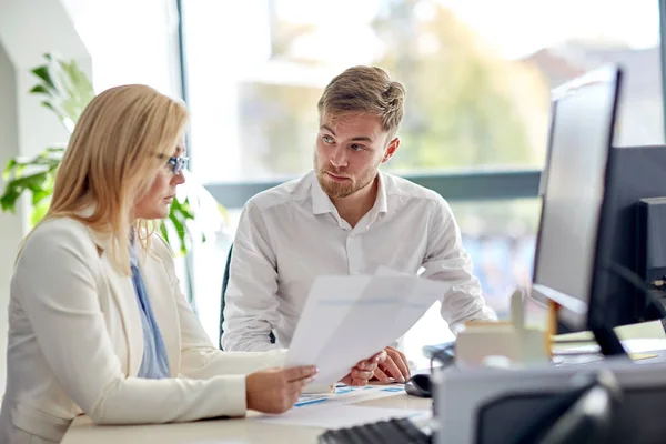 Business-team som diskuterar papper på office tabell — Stockfoto