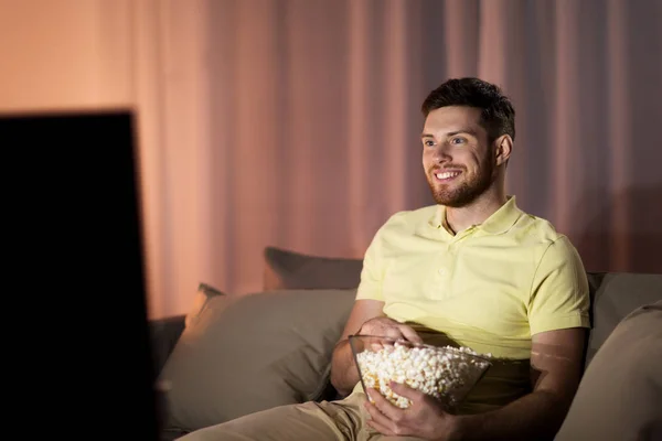 Happy man with popcorn watching tv at night — Stock Photo, Image