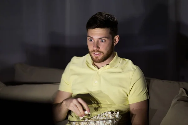 Uomo guardando la tv e mangiare popcorn di notte — Foto Stock