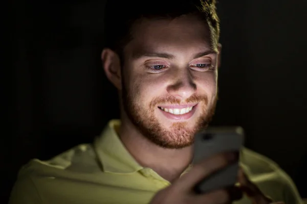 Heureux jeune homme avec smartphone la nuit — Photo