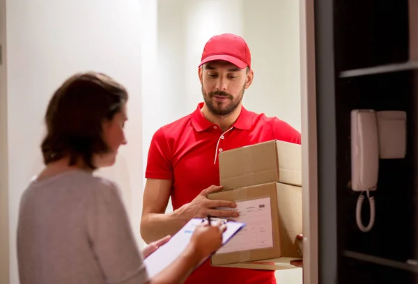Repartidor y cliente con cajas de paquetes en casa — Foto de Stock