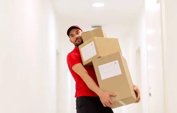 Livreur avec boîtes à colis dans le couloir — Photo