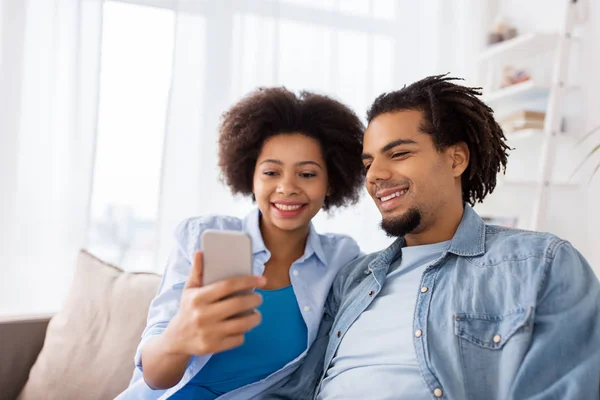 Feliz pareja con smartphones en casa — Foto de Stock