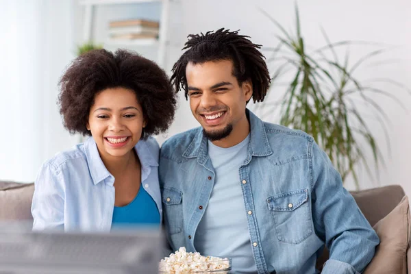Couple souriant avec popcorn regarder la télévision à la maison — Photo
