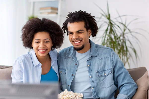 Sorrindo casal com pipocas assistindo tv em casa — Fotografia de Stock