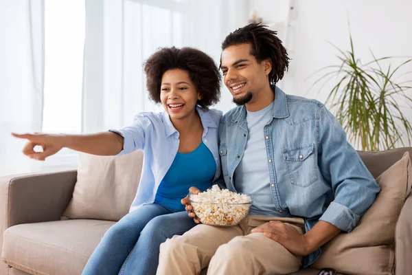 Sorrindo casal com pipocas assistindo tv em casa — Fotografia de Stock
