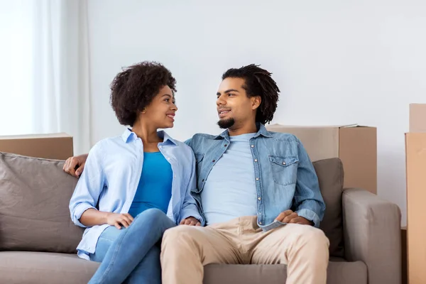 Casal feliz sentado no sofá e falando em casa — Fotografia de Stock