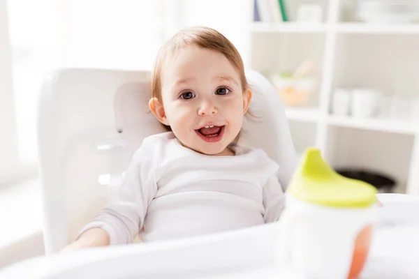 Boldog mosolygó baba etetőszék otthon ül — Stock Fotó