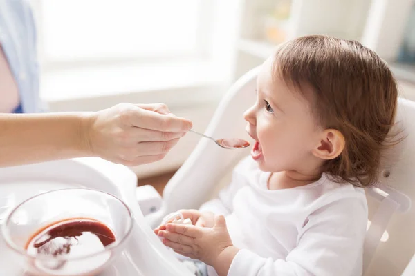 Moeder voeden van de baby met puree thuis — Stockfoto