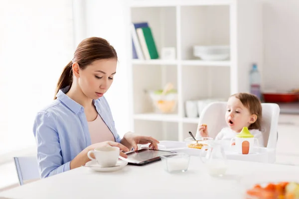 Feliz madre y bebé desayunando en casa — Foto de Stock