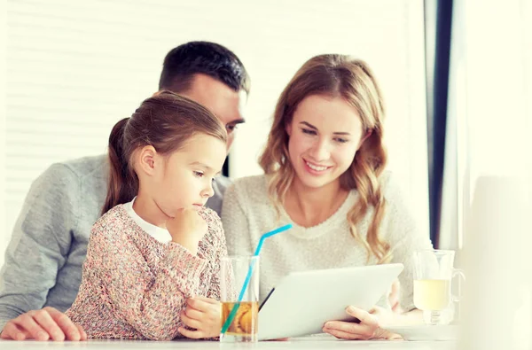 Happy family with tablet pc at restaurant — Stock Photo, Image