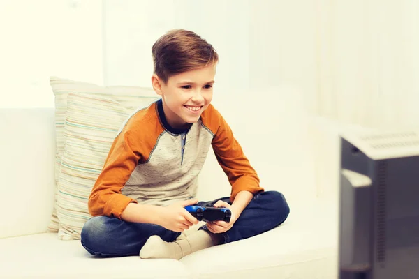 Lycklig pojke med joystick spelar videospel hemma — Stockfoto