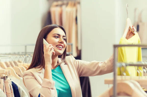 Mulher chamando no smartphone na loja de roupas — Fotografia de Stock