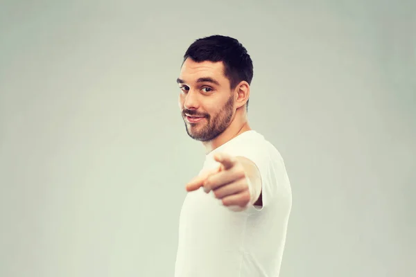 Mann zeigt mit dem Finger auf grauen Hintergrund — Stockfoto