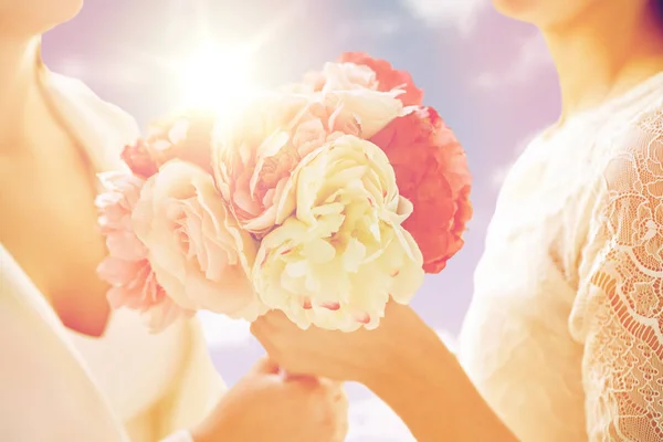 Close up de feliz casal lésbico com flores — Fotografia de Stock