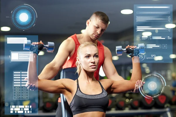 Homme et femme avec haltères dans la salle de gym — Photo