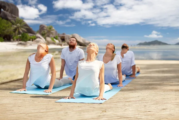 Gruppe von Leuten macht Yoga-Übungen über dem Strand — Stockfoto