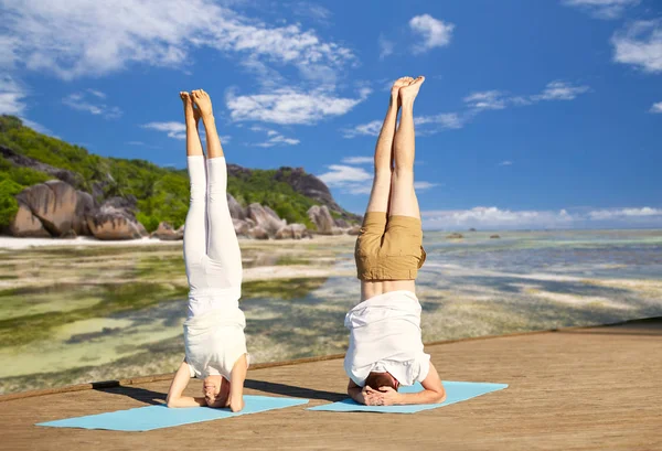 Couple making yoga headstand on mat outdoors — Stock Photo, Image