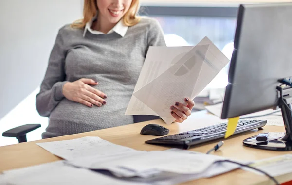 Femme d'affaires enceinte lecture de documents au bureau — Photo