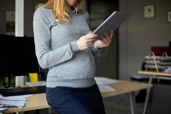 Femme d'affaires enceinte avec tablette PC au bureau — Photo