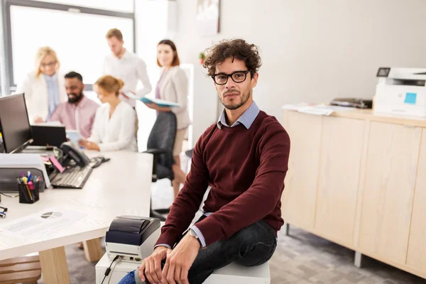 Happy young man over creative team in office — Stock Photo, Image