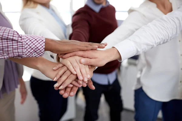 Feliz equipo de negocios con las manos en la parte superior en la oficina — Foto de Stock