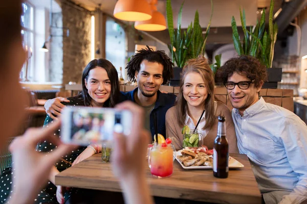 Vänner med smartphone fotograferar på café — Stockfoto