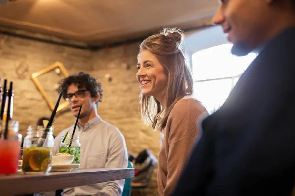 Happy friends eating and drinking at restaurant — Stock Photo, Image