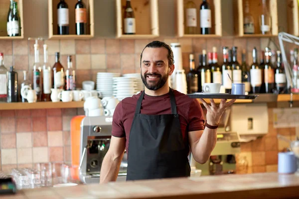 Gelukkig man of ober met koffie en suiker tegen bar — Stockfoto