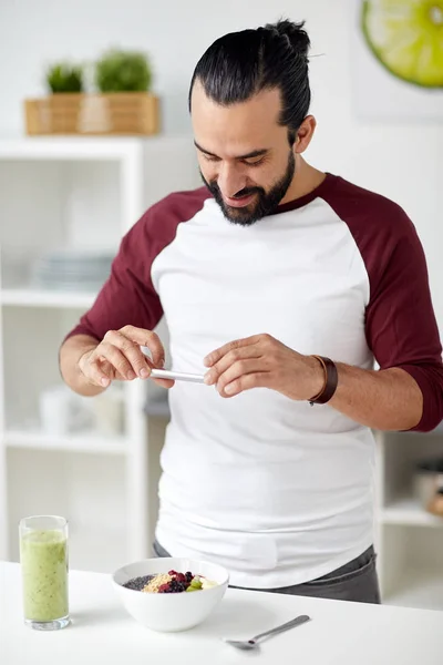 Hombre fotografiando el desayuno por teléfono inteligente en casa —  Fotos de Stock