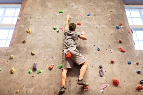 Jovem se exercitando no ginásio de escalada indoor — Fotografia de Stock